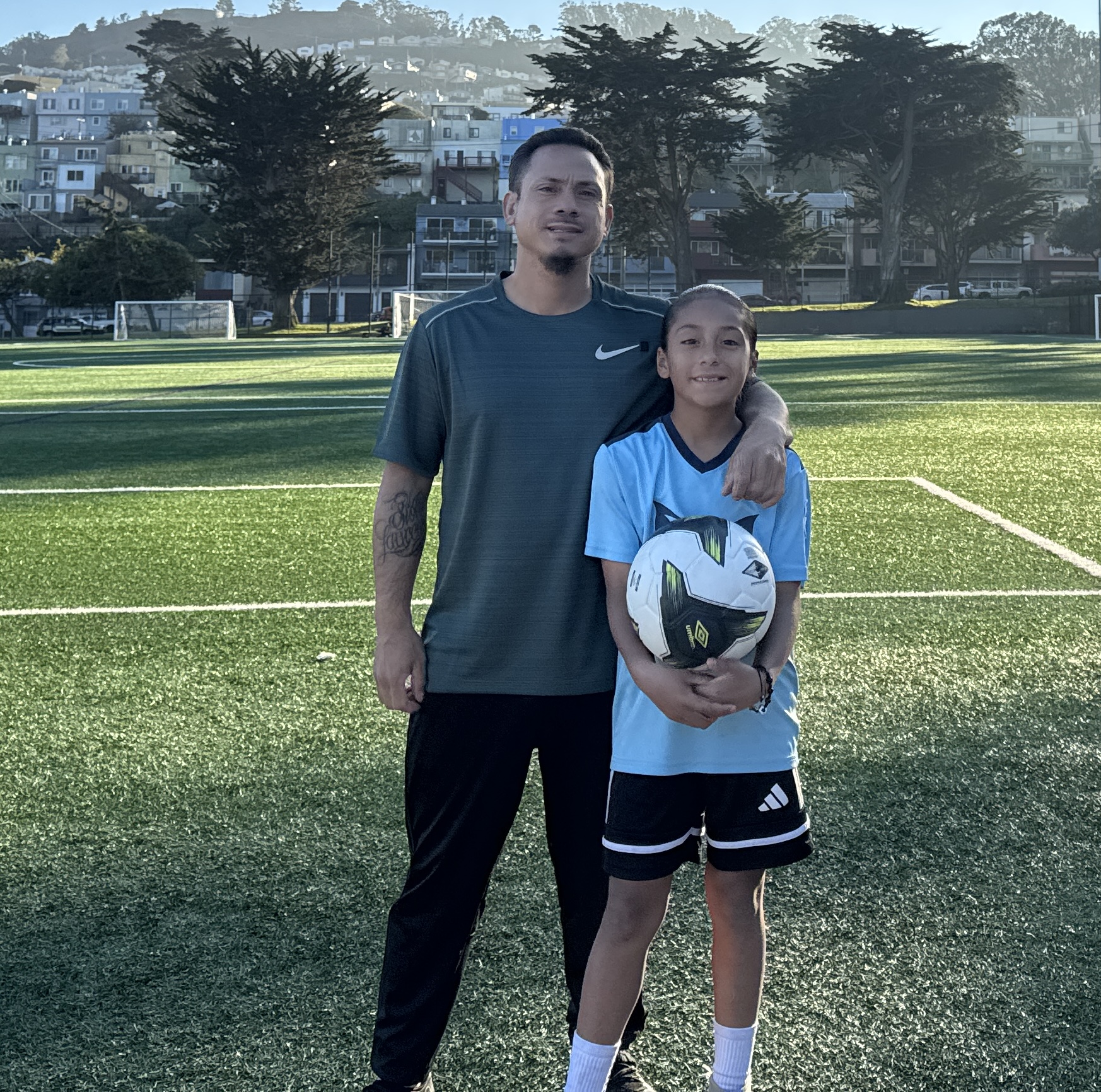 Coach and young player with soccer ball
